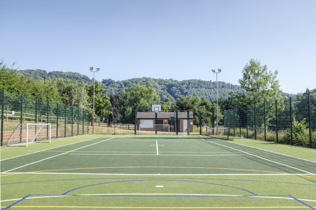 Sports pitch with tennis, football, netball, and basketball markings.